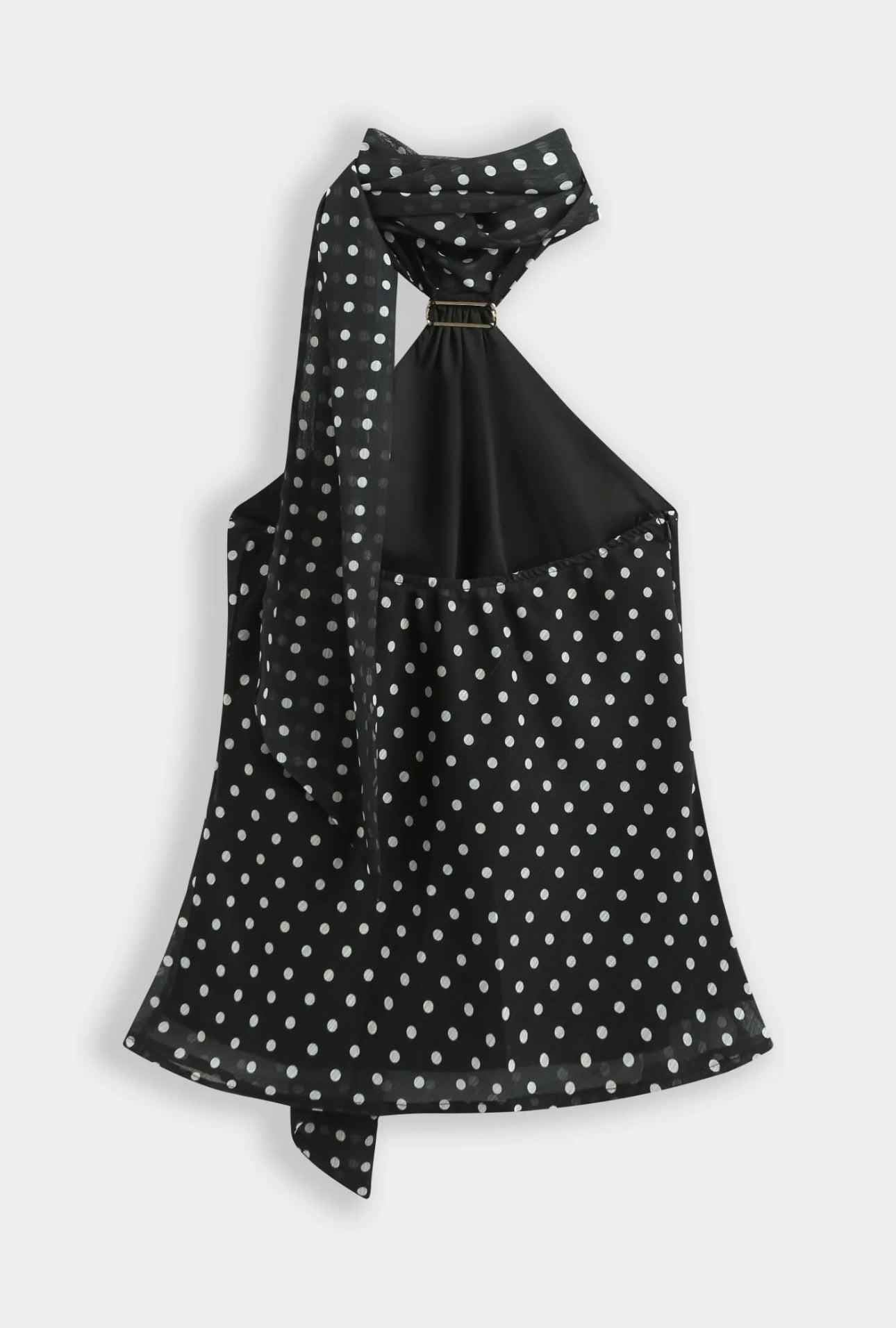 Top noir à pois blanc col foulard orné d’une broche dorée