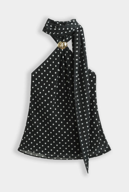 Top noir à pois blanc col foulard orné d’une broche dorée